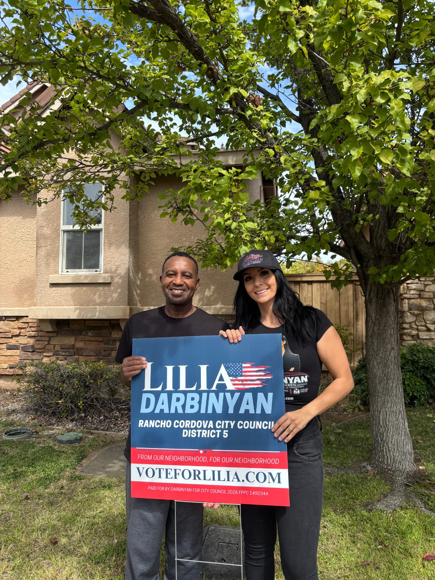 Lilia with a neighbor holding a Lilia Darbinyan yard sign